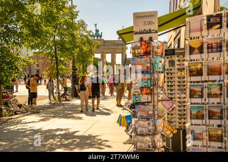 View of Brandenburg Gate, postcards and visitors in Pariser Platz on sunny day, Mitte, Berlin, Germany, Europe Stock Photo