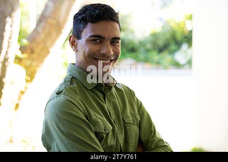 Portrait of happy biracial man standing next to window at home Stock Photo