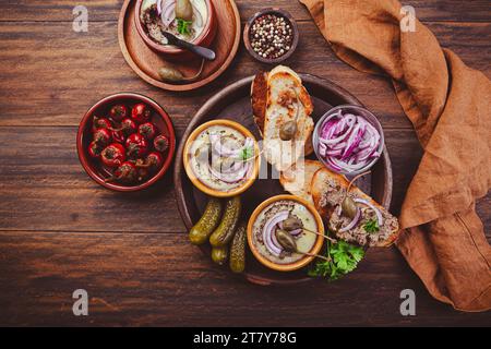 Fresh homemade chicken liver pate in ceramic bowls and appetizers on rustic background Stock Photo