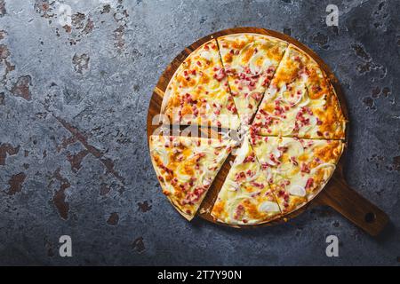 Traditional French dish tarte flambee with cream cheese, bacon and onions. Flammkuchen from Alsace region. Flame cake. Stock Photo