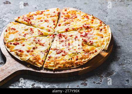 Traditional French dish tarte flambee with cream cheese, bacon and onions. Flammkuchen from Alsace region. Flame cake. Stock Photo