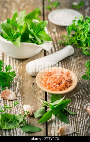 Thai basil and spicy herbs with Himalayan salt for healthy cooking on wooden table Stock Photo
