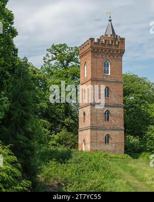 A brick built Gothic Tower in the woodlands at Painshill Park, Cobham, Surrey, England, UK. Stock Photo