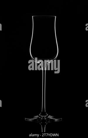 Empty glass wine glass on a black background. Wine glass for a drink on a black background. White silhouette of a glass. Stock Photo