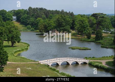 The roman style five arched Bridge over the Serpentine Lake  and The Gothic Temple overlooking the lake at Painshill Park, Cobham, Surrey, England, UK Stock Photo
