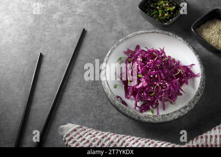 Red cabbage salad with sesame seeds, micro greens and sauce. Vegetarian food. Healthy cabbage salad. Red cabbage. Stock Photo