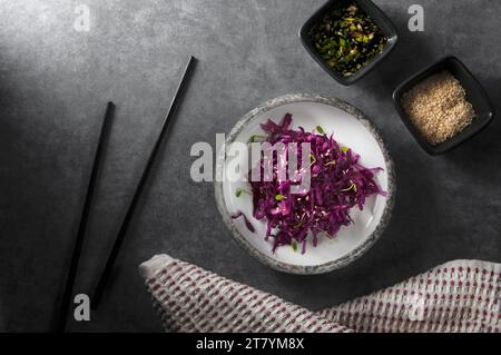 Red cabbage salad with sesame seeds, micro greens and sauce. Vegetarian food. Healthy cabbage salad. Red cabbage. Stock Photo