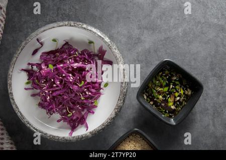 Red cabbage salad with sesame seeds, micro greens and sauce. Vegetarian food. Healthy cabbage salad. Red cabbage. Stock Photo