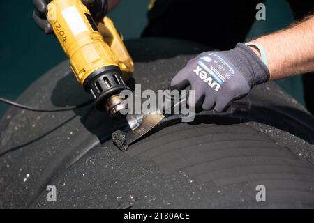 Pirelli’s engineers scrape down the tyres, marking each one by driver number and location of the tyre (front, rear, left or right) and collect data about the wear of the tyre that they then share with that team and the FIA, Mexican City Grand Prix, Mexico, 27 October 2023.  Each team is allocated one Pirelli engineer who can make suggestions based on the wear of the tyres.  Pirelli had one female track engineer at the Mexico City race, Mrs Monica Cuadrado, allocated to the Alpha Tauri team.    After the race in Qatar, the team noticed significant wear on one of the wheels, caused by pyramid cu Stock Photo