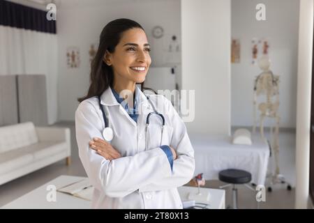 Happy young practitioner doctor posing in medical office Stock Photo