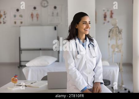 Happy young cardiologist woman posing at workplace Stock Photo