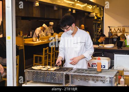 Tokyo, Japan - April 12, 2023: street restaurant on Tsukiji Fish Market with unidentified people. It is a major tourist attraction. Before 2018, it wa Stock Photo