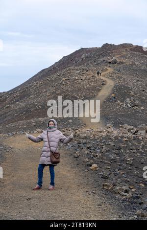 Happy tourist on hiking trip near Fagradalsfjall hike road in southwest Iceland Reykjanes Peninsula Stock Photo