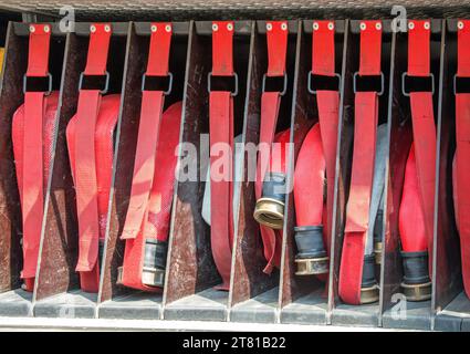 many red fire hoses of firefighters placed inside the fire truck Stock Photo