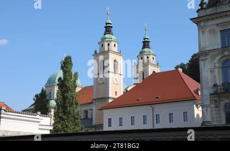 Two bell towers with a dome with copper roofing of St. Nicholas Church  in Ljubljana capital of Slovenia in central Europe Stock Photo