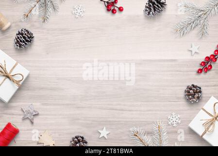 Top view flat lay Christmas composition on wooden table with festive decorations, featuring copy space in the center Stock Photo