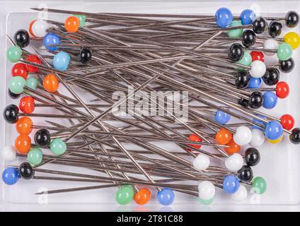 Many multi-colored sewing pins on a white background Stock Photo