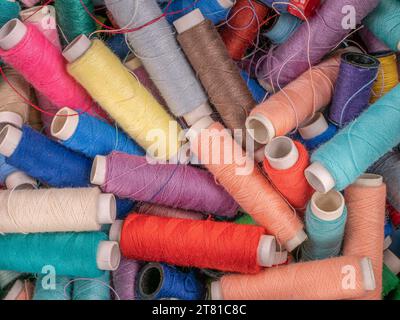 Many colorful sewing threads on spools Stock Photo