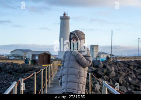 Happy women tourist near Lighthouse on Gardskagi in southwest Iceland Reykjanes Peninsula Stock Photo