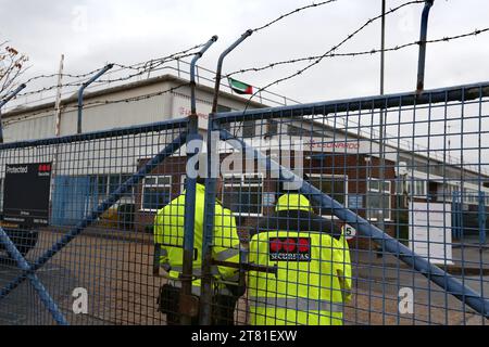 Southampton, Hampshire, UK. 16th Nov, 2023. Security guards stand-by the gate while a Palestine flag flies from the rooftop. Palestine Action occupy the roof of Italian arms industry, giant Leonardo at their factory in Southampton. Leonardo supply Israel with fighter jets and weaponry that are currently being used in Gaza. Palestine Action demands that arms companies providing weapons for Israel should be shut down permanently. They have announced that companies selling weapons to the Israeli Defence Force and their partner companies will be targeted with direct action. These ac Stock Photo