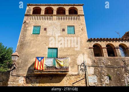 Catalan estelada unofficial star flag and banner promoting Catalunya independence hanging from a balcony in the village of Pals, Catalonia, Spain Stock Photo