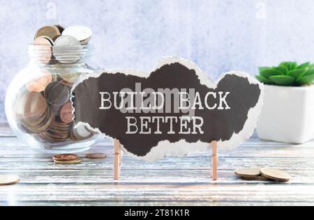 Build back better text on a notepad page on a gray background near banknotes and a magnifying glass. Stock Photo