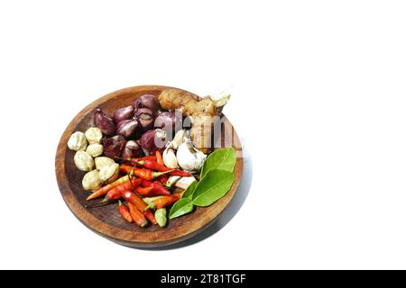 various kinds of kitchen spices are placed on a wooden plate, on a white background Stock Photo