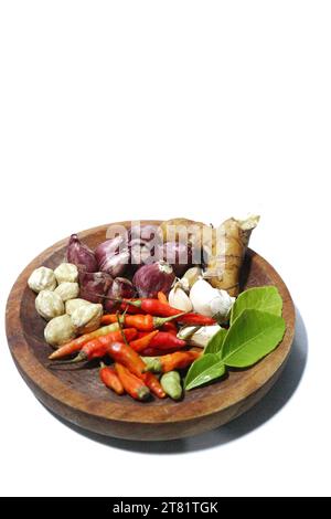 various kinds of kitchen spices are placed on a wooden plate, on a white background Stock Photo
