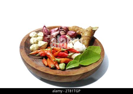various kinds of kitchen spices are placed on a wooden plate, on a white background Stock Photo
