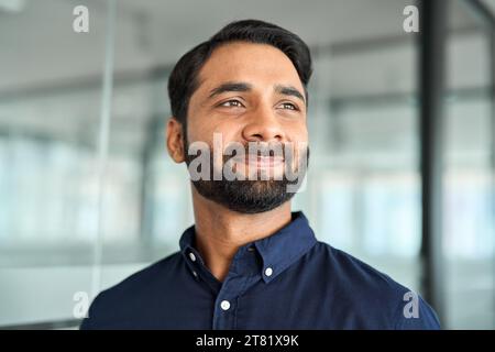 Confident Indian business man in office looking away, headshot face portrait. Stock Photo