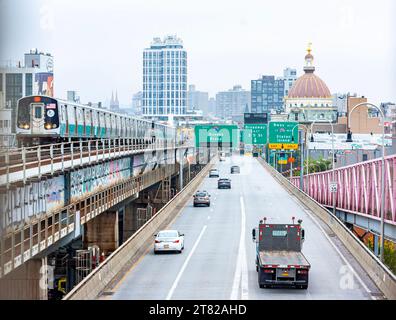 A subway train and traffic on the Williamsburg Bridge between Manhattan and Brooklyn, New York City, taxi heading to Queens and the Bronx Stock Photo