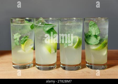 Vibrant glasses of refreshing Mojito drinks, adorned with lime wedges, ice cubes, and fresh mint leaves. Ideal for lively gatherings and festive occas Stock Photo
