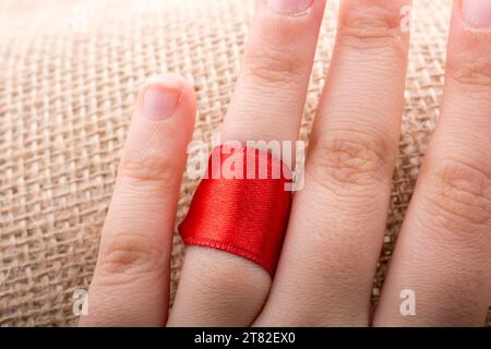 Red string tied around ring finger of the hand Stock Photo