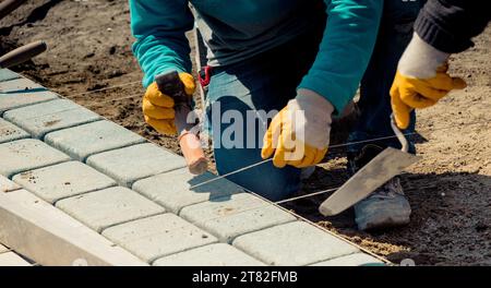 Cobblestone installation, paver laying granite stone pavers using industrial cobblestones Stock Photo