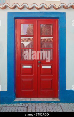Tiny door painted with vivid colors at Vila Nova de Milfontes house. Little picturesque town on the Alentejo coast, Portugal Stock Photo