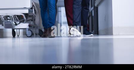 Lowsection of biracial male doctors walking in hospital corridor Stock Photo