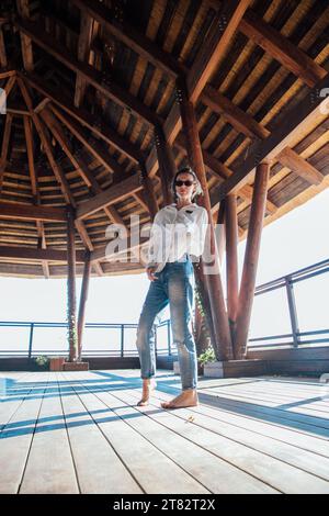 a woman stands under a canopy on a walk Stock Photo