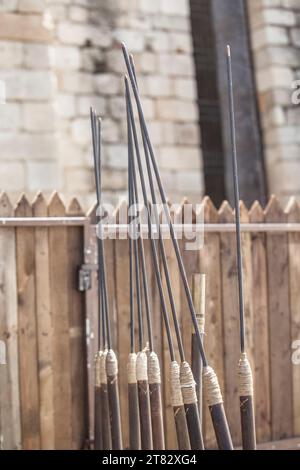 Stand full of pila or roman javelins at military camp. Perimeter palisade as background Stock Photo