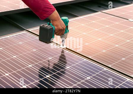 Technician installing solar panels by screwdriver, Renewable energy clean and good environment. Stock Photo