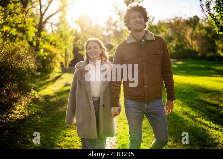 Portrait of happy loving couple walking in park in sunset. Stock Photo