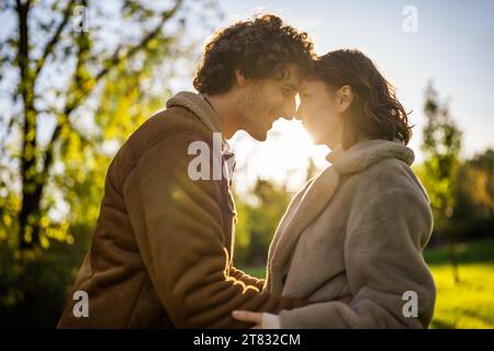 Portrait of happy loving couple in park in sunset. Stock Photo