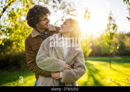 Happy loving couple embracing in park in sunset. Stock Photo
