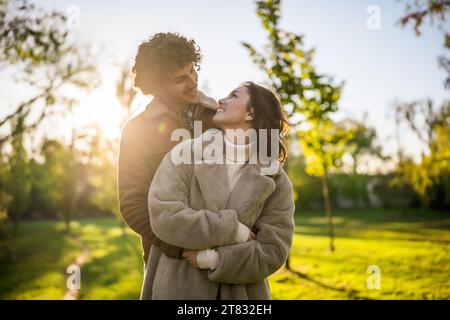 Happy loving couple embracing in park in sunset. Stock Photo