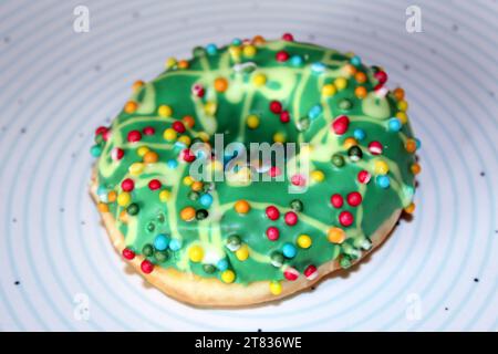 One green glazed doughnut isolated on blue circles plate Stock Photo