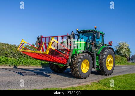 Albutt farming attachments on modern John Deer tractor travelling on rural roads in Cheshire UK Stock Photo