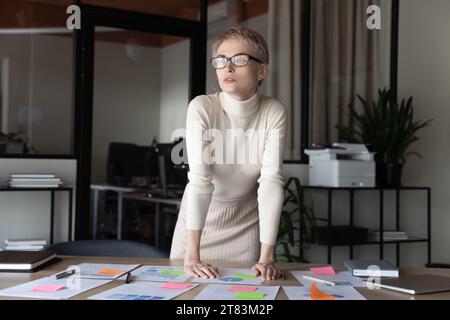 Serious thoughtful business woman wearing glasses, looking away Stock Photo