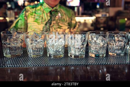 Empty cocktail glass with ice cubes on counter bar in nightclub Stock Photo