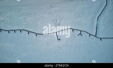Snow-covered ground with natural patterns and footprints Stock Photo