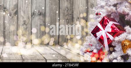 Christmas tree with wooden rustic decorations and presents under it in loft interior. Stock Photo