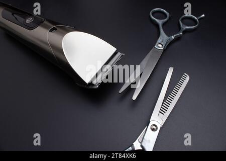 Hairdressing scissors and Machine for a hairstyle on black background. Hairdresser salon equipment concept, premium hairdressing shears. Accessories f Stock Photo